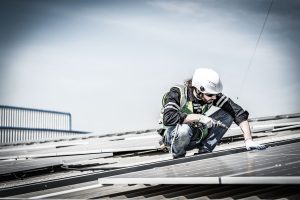 Male engineer installing or checking the working condition of solar panels on the roof or at the height of the factory for saving electricity was broken to use renewable energy from the sun