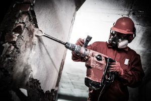 Demolition and construction destroying. worker with hammer breaking interior wall plastering